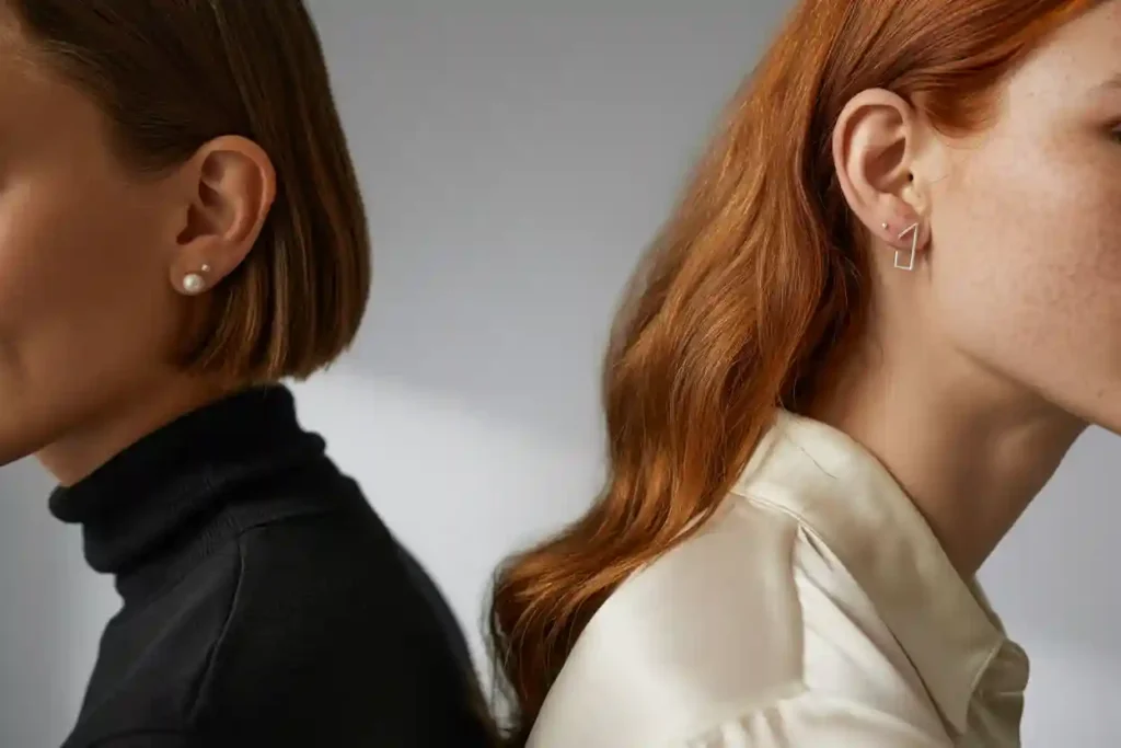 femme aux cheveux couurts et femme aux cheveux logs lâchés qui portent des clous d'oreilles