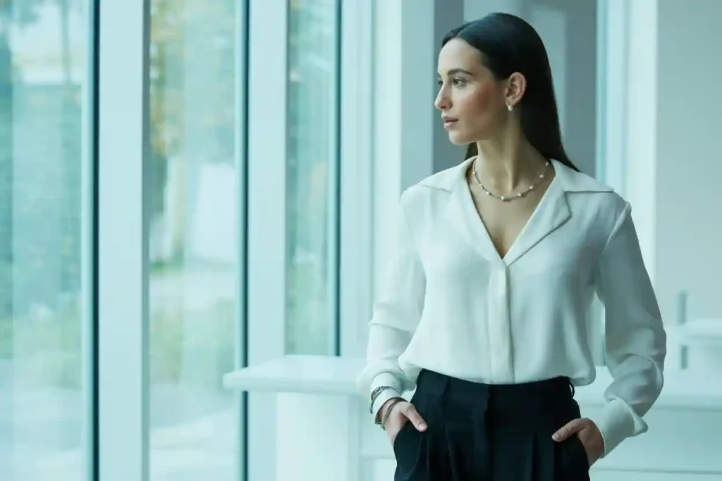 femme en chemisier blanc qui porte de magnifiques bijoux