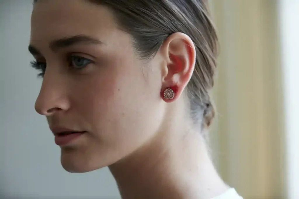 femme qui a une rougeur au niveau de son trou d'oreille