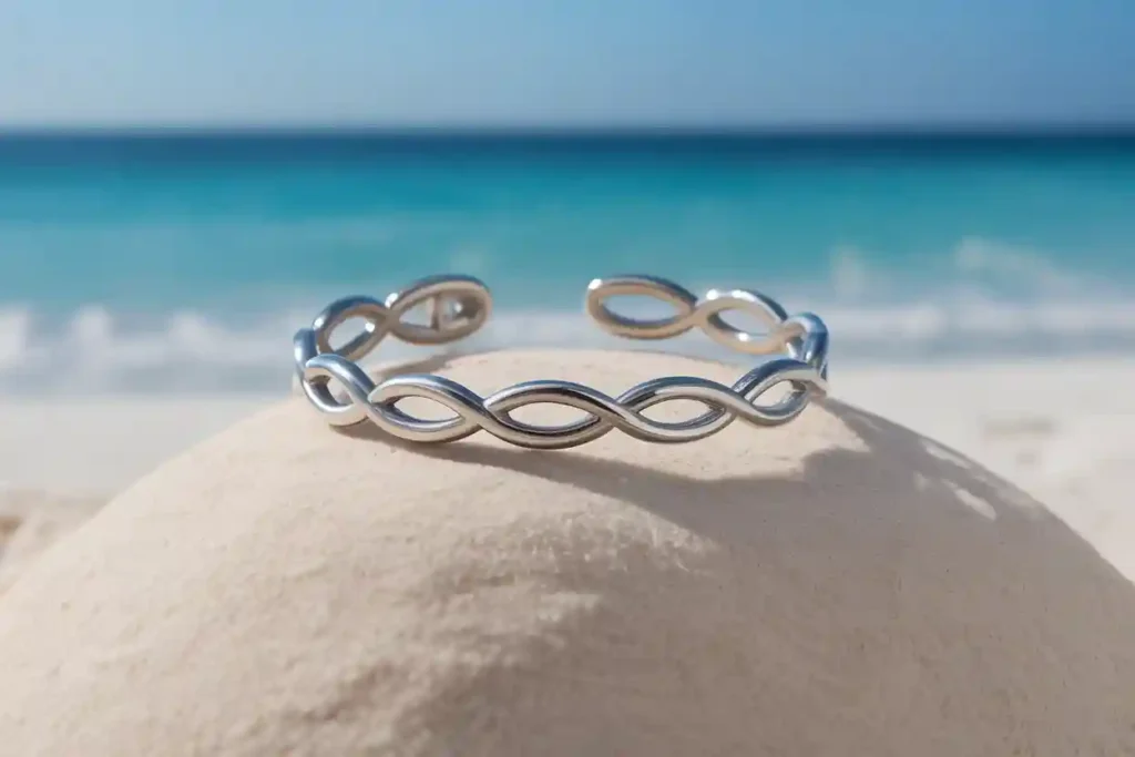 bracelet en acier inoxydable posé sur le sable près de la mer