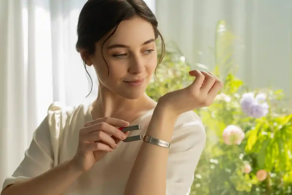 femme qui met un aimant près de son bracelet en acier inoxydable