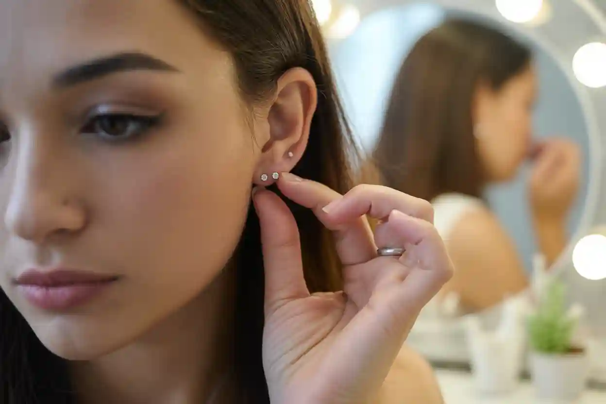 femme qui porte 3 puces d'oreilles