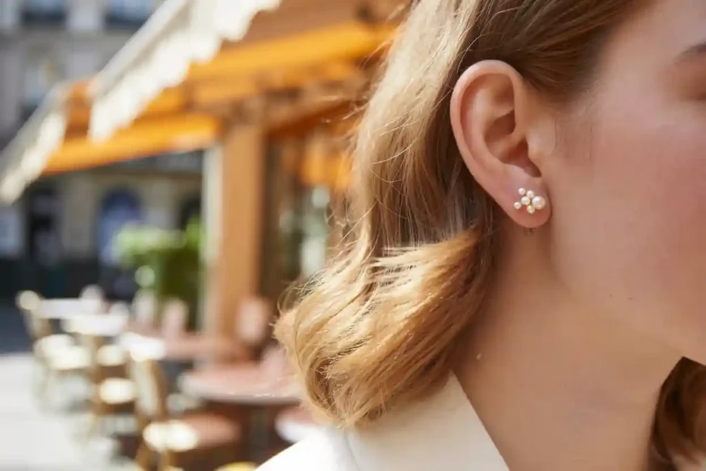 femme qui porte des clous d'oreilles e forme de plusieurs perles