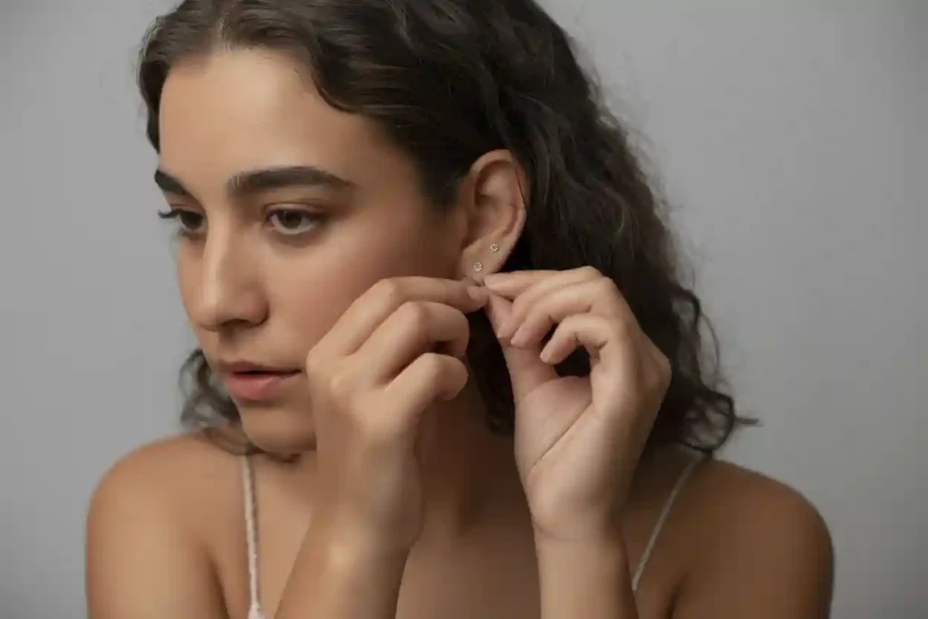 femme qui retire ses puces d'oreilles