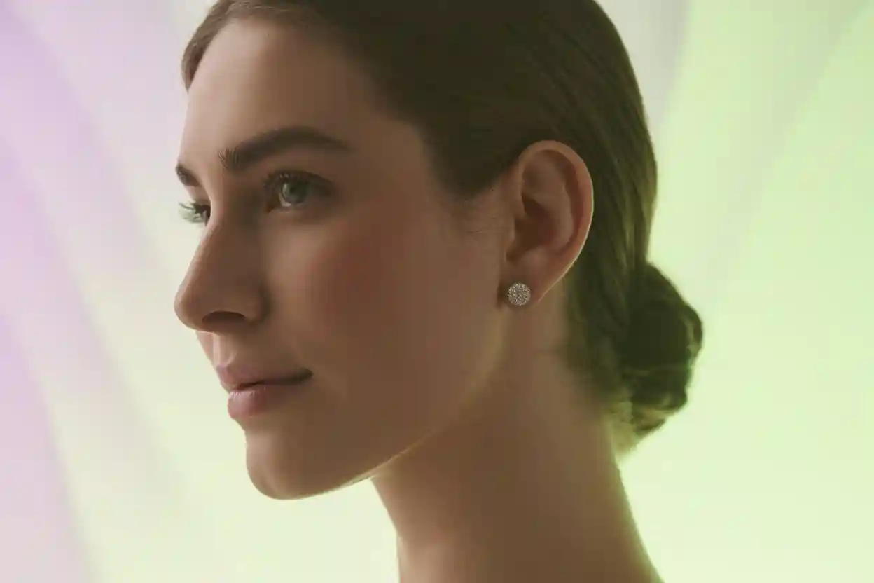 visage de femme de profil qui porte des clous d'oreilles